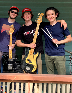 David McKellar, Ben Grodner, and Mansur Zhussupbekov on porch with guitars.