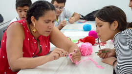 Ana Maria Porras crochets with a student doing an event of Clubes de Ciencia in Bucaramanga, Colombia