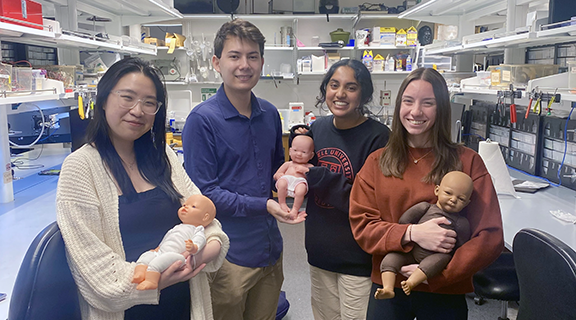 Undergraduates in the BME Design Lab holding infant dolls