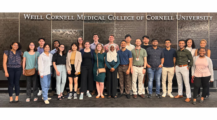 2022 PhD immersion cohort of student standing in front of Weill Cornell Medicine sign in NYC
