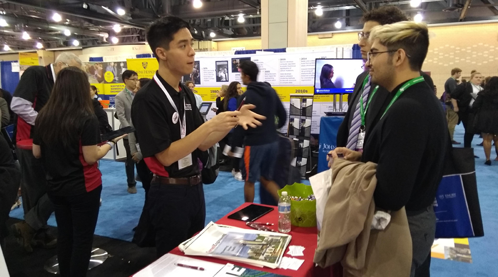 Student talking with candidate students at booth at BMES 2019
