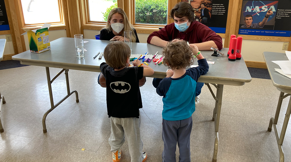 students work with children at workshop event
